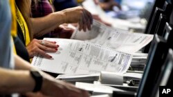 FILE - Election workers perform a recount of ballots from the recent Pennsylvania primary election at the Allegheny County Election Division warehouse in Pittsburgh on June 1, 2022.