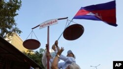 រូបឯកសារ៖ សកម្មជនសិទ្ធិមនុស្សរៀបចំតាំងជញ្ជីងយុត្តិធម៌ ក្នុងកម្មវិធីដើរហែក្បួនមួយដើម្បីអបអរសាទរខួប៧៥ឆ្នាំនៃទិវាសិទ្ធិមនុស្សអន្តរជាតិ នៅរាជធានីភ្នំពេញ កាលពីថ្ងៃទី១០ ខែធ្នូ ឆ្នាំ២០២៣។