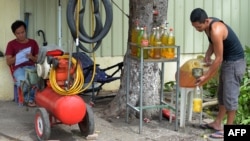 រូបឯកសារ៖ បុរសម្នាក់កំពុងចាក់សាំងដាក់ដប នៅរាជធានីភ្នំពេញ កាលពីថ្ងៃទី ៣០ ខែសីហា ឆ្នាំ ២០១៨។ 