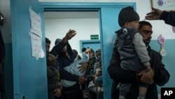 Palestinians line up with their children to receive vaccine shots for them, in Rafah, southern Gaza Strip, Jan. 2, 2024. Vaccines were unavailable for weeks due to the war and are still scarce in many parts of Gaza.