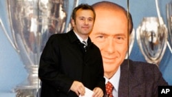 Dejan Savićević, nekadašnji fudbaler Crvene zvezde i Milana ispred fotografije Silvija Berluskonija na svečanosti u Milanu 2011. (Foto: AP/Antonio Calanni)