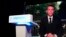 French President Emmanuel Macron appears on television screen at the French far-right National Rally party election night headquarters, in Paris, June 9, 2024. Macron dissolved the National Assembly and called for a new legislative election.