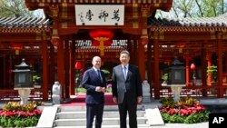 In this photo released by Xinhua News Agency, Chinese President Xi Jinping, right and German Chancellor Olaf Scholz pose in Beijing, China, April 16, 2024.