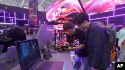 Visitors review new computer products during the Computex Taipei exhibition, one of the world's largest computer and technology expos in Taipei, Taiwan, June 4, 2024. 