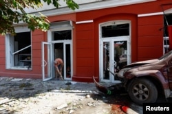 Seorang pria membersihkan rumahnya yang rusak akibat serangan rudal Rusia di Kota Chernihiv, Ukraina, Sabtu 19 Agustus 2023. (Foto: Valentyn Ogirenko/Reuters)