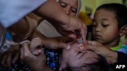 Seorang petugas kesehatan memberikan vaksin polio kepada seorang anak di Puskesmas di Bogor, Jawa Barat, 3 April 2023. (Foto: Aditya Aji/AFP)