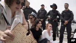 Polisi Israel menghalangi aktivis dan delegasi rabi Amerika dan Israel dari Rabbis for Ceasefire yang berbaris menuju penyeberangan Erez ke Jalur Gaza dengan bantuan makanan untuk warga sipil Gaza di Israel selatan, Jumat, 26 April 2024. (AP/Maya Alleruzzo)