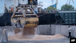 FILE - Workers load grain at a grain port in Izmail, Ukraine, April 26, 2023.
