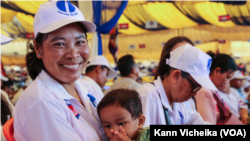 អ្នកស្រី សន ភារម្យ សមាជិកចលនាស្រ្តីគណបក្សភ្លើងទៀនក្នុងសង្កាត់លលកស ក្រុងពោធិ៍សាត់ ខេត្តពោធិ៍សាត់ កំពុងបីកូនចូលរួមសមាជវិសាមញ្ញគណបក្សភ្លើងទៀន នៅថ្ងៃទី១១ ខែកុម្ភៈ ឆ្នាំ២០២៣ នៅខេត្តសៀមរាប។ (កាន់ វិច្ឆិកា/វីអូអេ)