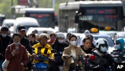 北京金融区街头早高峰时间的上班车辆人群。（2023年4月18日）