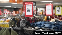 Seorang karyawan menunggu pelanggan di sebuah mall di Denpasar, Bali pada 5 Mei 2023. (Foto: AFP/Sonny Tumbelaka)