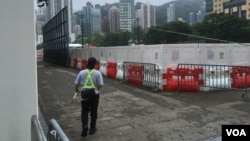 A carnival worker guards the perimeter of a closed-off soccer field which traditionally had been used for Tiananmen Square crackdown commemorations, at Victoria Park, Hong Kong, June 4, 2024. (Cindy Sui/VOA)