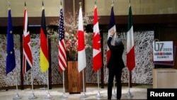 资料照：一名男子在日本东京举行七国集团外交部长会议期间整理成员的旗帜。（2023年11月8日）