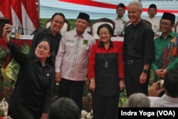 Puan Maharani berswafoto bersama dengan Ganjar Pranowo dan Mahfud MD setelah deklarasi keduanya sebagai pasangan calon presiden dan calon wakil presiden yang diusung PDI-P, di Jakarta, Rabu, 18 Oktober 2023. (Foto: Indra Yoga/VOA)