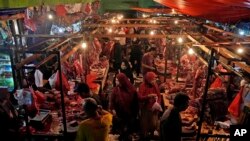 Masyarakat berbelanja daging di sebuah pasar di Jakarta, Selasa, 9 April 2024, untuk berbelanja bahan makanan menyambut hari raya Idulfitri, menandai berakhirnya bulan suci Ramadan. (AP/Dita Alangkara)