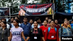 Sejumlah mahasiswa kedokteran saling berpegangan tangan dalam aksi protes terhadap pembunuhan dan pemerkosaan yang menimpa seorang dokter muda di Kolkata, India. Aksi berlangsung pada 14 Agustus 2024. (Foto: Reuters/Sahiba Chawdhary)