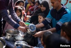 Anak-anak Palestina menunggu untuk menerima makanan di Rafah, di selatan Jalur Gaza, 5 Maret 2024. (Foto: Reuters)