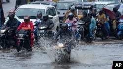 Para pengendara motor melewati jalan tergenang akibat hujan lebat di Hyderabad, India, 5
September 2023. Meski September hujan, curah hujannya tercatat paling rendah sejak 2018 akibat El Nino pada Agustus. (Foto: Mahesh Kumar/AP Photo)
