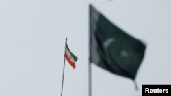 Bendera Iran terlihat di gedung konsulatnya, dengan bendera Pakistan di latar depan. Pakistan mengatakan negara tersebut melakukan serangan di dalam wilayah Iran yang menargetkan militan separatis, Karachi, Pakistan, 18 Januari 2024. (Foto: REUTERS/Akhtar Soomro)