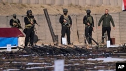 Pasukan Mobilisasi Populer (PMF) memperlihatkan senjata yang disita dari anggota militan kelompok ISIS di provinsi Salahuddin, di utara Baghdad, Irak, pada 12 Januari 2023. (Foto: AP/Hadi Mizban)