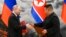 Russian President Vladimir Putin, left, and North Korea's leader Kim Jong Un exchange documents during a signing ceremony of the new partnership in Pyongyang, North Korea, June 19, 2024.