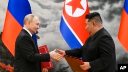 Presiden Rusia Vladimir Putin dan Pemimpin Korea Utara Kim Jong Un bertukar dokumen dalam acara penandatanganan perjanjian kemitraan baru antara kedua negara di Pyongyang, Korea Utara, 19 Juni 2024. (Foto: Kristina Kormilitsyna, Sputnik, Kremlin Pool Photo via AP)