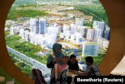 Seorang agen real estate (tengah) berbincang dengan pelanggan saat Indonesia Property Expo 2016 di Jakarta, 16 Februari 2016. (Foto: REUTERS/Beawiharta)