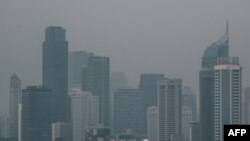 Gedung-gedung pencakar langit di tengah kabut asap akibat polusi udara di Jakarta, 23 Agustus 2023. (Yasuyoshi CHIBA/AFP)