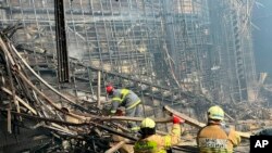 Crews work inside the Crocus City Hall on the western edge of Moscow, March 23, 2024, following an attack Friday, for which the Islamic State group claimed responsibility. (Russian Emergency Ministry Press Service via AP) 
