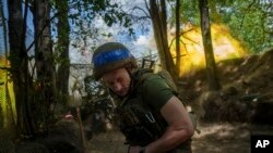 A Ukrainian national guard serviceman aka "Master" of Khartia brigade fires by a D-20 cannon towards Russian positions at the front line near Kharkiv, Ukraine, June 10, 2024.