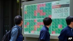 Sebuah monitor menampilkan indeks Nikkei 225 Jepang di sebuah perusahaan sekuritas di Tokyo, Kamis, 27 Juli 2023. Pasar-pasar saham Asia terjun bebas pada Jumat (19/4). (Foto: AP)