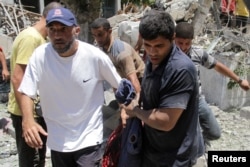 Palestinians carry a casualty outside the headquarters of UNRWA (United Nations Relief and Works Agency) following an Israeli strike in Gaza City, June 23, 2024.