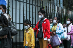 អ្នកស្រី ពិន ឃន់ អាយុ ៣៣ ឆ្នាំ និងកូនស្រី កំពុងឈរតម្រង់ជួរចូលមន្ទីរពេទ្យគន្ធបុប្ផា ដើម្បីទទួលបានការព្យាបាលជំងឺដល់កូនស្រី ដែលត្រូវការការវះកាត់ នៅរាជធានីភ្នំពេញ កាលពីថ្ងៃទី ១ ខែមីនា ឆ្នាំ ២០២៣។ (ទែន សុខស្រីនិត/វីអូអេ)