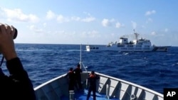 资料照:菲律宾海岸警卫队发布照片显示,一艘中国海警船(上)正在有争议的南中国海阻拦一艘菲律宾政府船只登陆铁线礁(Sandy Cay )。(2024年3月21日)