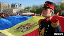 Članovi počasne garde drže moldavsku zastavu tokom ceremonije obeležavanja Dana državne zastave u Kišinjevu, Moldavija, 27. april 2023. (Foto: REUTERS/Vladislav Culiomza)