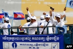 FILE - Supporters of the Candlelight Party (CP) shout slogans from a vehicle during a rally on the last day of campaigning for the commune elections in Phnom Penh on June 3, 2022.