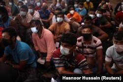 Para pekerja migran berkumpul di kompleks asrama mereka untuk pemeriksaan dokumen, selama operasi bersama Departemen Tenaga Kerja di Kuala Lumpur, Malaysia, 17 Maret 2022. (Foto: REUTERS/Hasnoor Hussain)