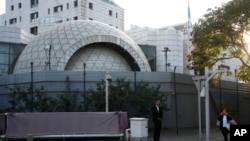 A plainclothes security person stands watch outside the Israeli Embassy in Beijing, Oct. 13, 2023. 