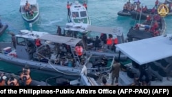 Personel Garda Pantai China (kiri, kanan) menghalangi kapal Angkatan Laut Filipina (tengah) selama konfrontasi di Second Thomas Shoal di Laut Cina Selatan. (Foto: AFP)