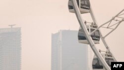 Asap yang ditimbulkan dari kebakaran hutan di utara Quebec menyeliputi langit kota Montreal, Kanada, pada 25 Juni 2023. Situasi tersebut membuat kualitas udara di kota itu memburuk. (Foto: AFP/Andrej Ivanov)