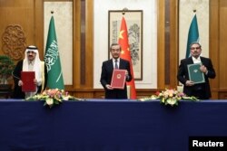 Wang Yi, diplomat senior China (tengah), menghadiri pertemuan dengan Sekretaris Dewan Keamanan Nasional Tertinggi Iran Ali Shamkhani dan Menteri Negara dan Penasihat Keamanan Nasional Arab Saudi Musaad bin Mohammed Al Aiban di Beijing, China, 10 Maret 2023. (China Daily via REUTERS)