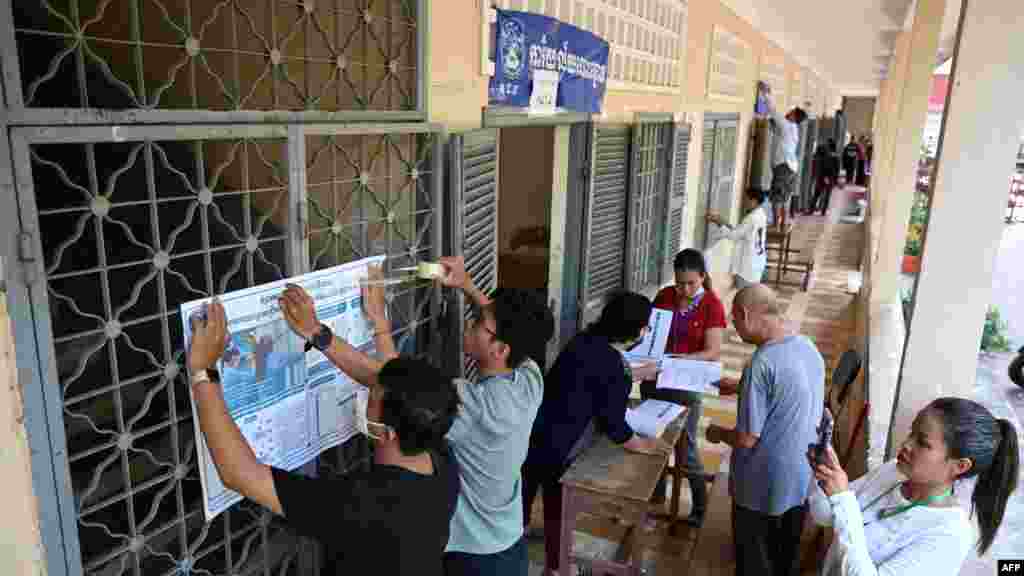 មន្ត្រីរៀបចំការបោះឆ្នោតបិទខិត្តបណ្ណព័ត៌មាននៅមណ្ឌលបោះឆ្នោតមួយកន្លែង មុនថ្ងៃបោះឆ្នោតជាតិអាណត្តិទី ៧ នៅរាជធានីភ្នំពេញ ថ្ងៃទី ២២ ខែកក្កដា ឆ្នាំ ២០២៣។ 