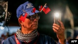 A supporter wears Taiwan national flags on his hat during an election campaign rally in Keelung on Jan. 4, 2024.