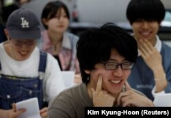 Para siswa berlatih tersenyum pada kursus pelatihan senyum di Sekolah Seni Sokei di Tokyo, Jepang, 30 Mei 2023. (Foto: REUTERS/Kim Kyung-Hoon)