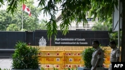 FILE - Security personnel stand guard in front of the High Commission of Canada in New Delhi on Sept. 19, 2023.