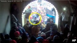 FILE - This image of Larry Fife Giberson, circled by the Justice Department in its statement of facts supporting his arrest, shows him outside the U.S. Capitol on Jan 6. 2021. Giberson pleaded guilty July 31, 2023, to joining an attack on police.