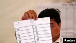 រូបឯកសារ៖ មន្ត្រីរៀបចំការបោះឆ្នោតម្នាក់បង្ហាញសន្លឹកឆ្នោត ពេលរាប់សន្លឹកឆ្នោត ក្នុងអំឡុងការបោះឆ្នាតជាតិ​អាណត្តិទី ៦ នៅរាជធានីភ្នំពេញ កាលពីថ្ងៃទី ២៩ ខែកក្កដា ឆ្នាំ ២០១៨។ 