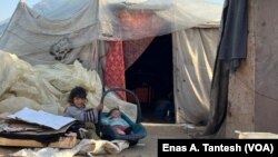 Children rest outside a makeshift camp in Rafah, Gaza, March 2, 2024. Roughly 17,000 children have been separated or lost their parents in Gaza.