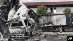 FILE - A Thai officer stands beside a burned-out oil tanker at a gas station in Pattani province, southern Thailand, Aug. 17, 2022. Thailand’s southernmost provinces have been the scene of an active Muslim separatist insurgency for almost two decades. 