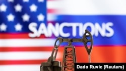 ILUSTRACIJA - Model pumpe za vađenje nafte ispred reči "Sankcije", američke i ruske zastave (Foto: Reuters/Dado Ruvić)